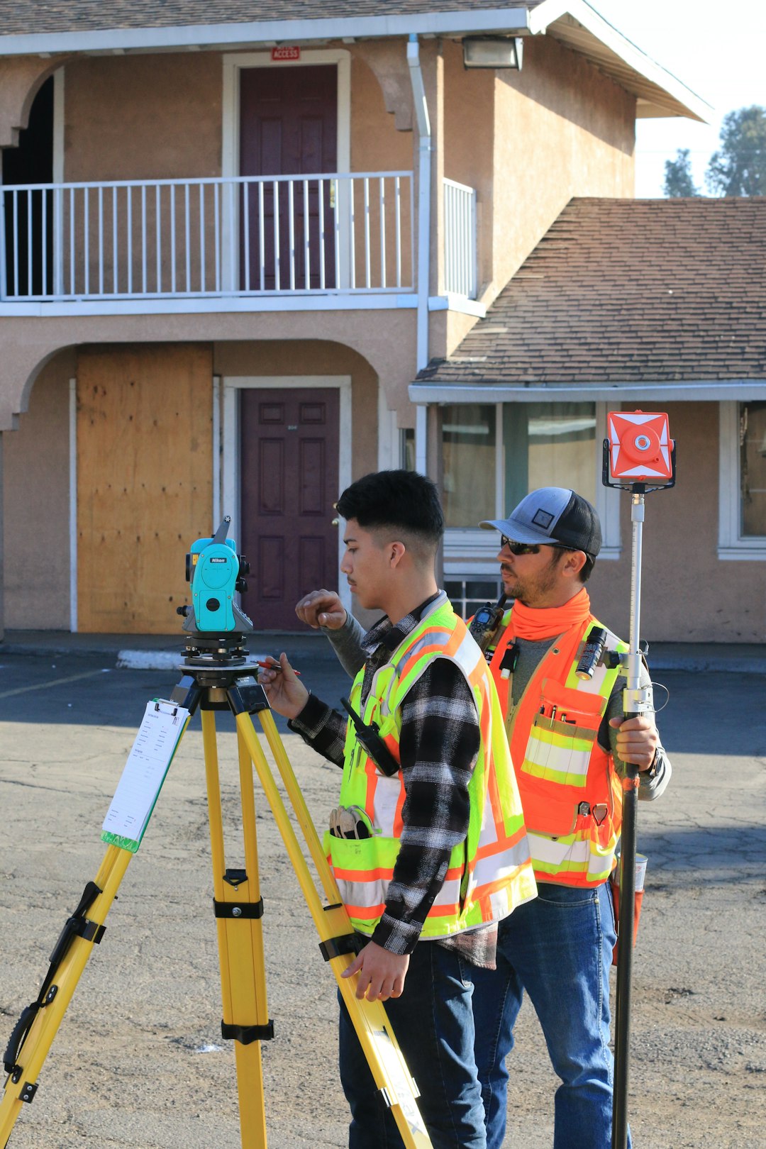 man-in-yellow-and-black-plaid-shirt-holding-green-and-black-camera-u9ns7cve-h4